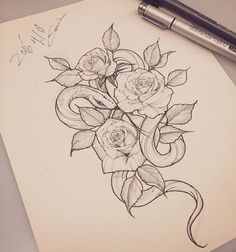 a pencil drawing of roses on top of a piece of paper next to a pen