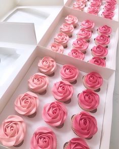 pink cupcakes are displayed in white boxes