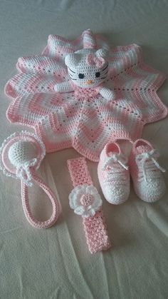 a crocheted baby outfit and booties are laying on a bed