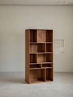 an empty bookcase in the corner of a room with white walls and flooring