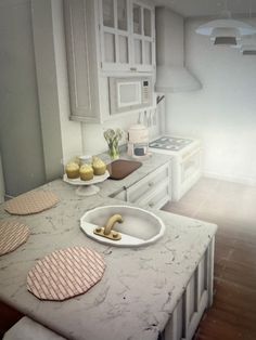 a white kitchen with cupcakes on the counter and plates in front of it