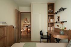 a bed room with a neatly made bed next to a desk and bookcases