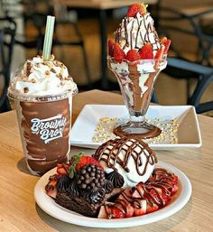 two desserts are on the table with ice cream and strawberries