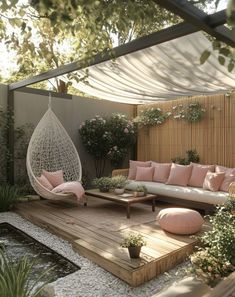 an outdoor living area with hammock, couches and potted planters