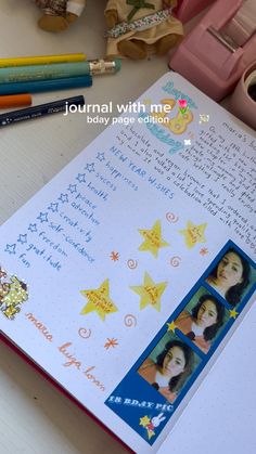 an open notebook with pictures and writing on the pages next to some crayons