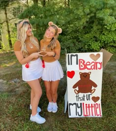 two girls standing next to a sign that says i'm bear that our my little