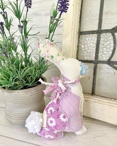 a stuffed animal sitting next to a potted plant