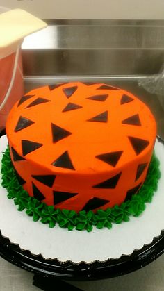 an orange and black cake sitting on top of a white plate