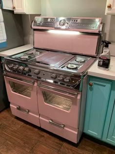 a pink stove top oven sitting inside of a kitchen