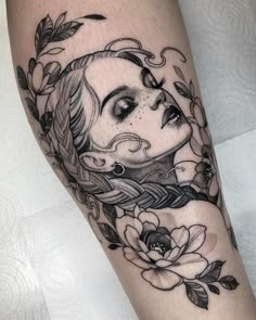 a woman's face with flowers and leaves around her legs, on the leg