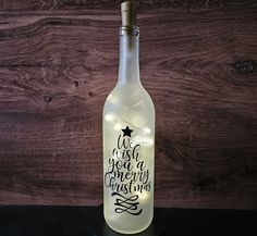 a lighted bottle that says, we wish you a merry christmas on the front and side