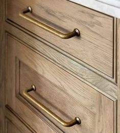 a close up of a wooden dresser with brass handles