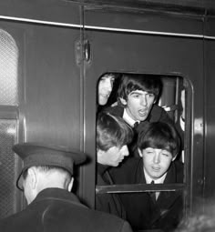 black and white photograph of the beatles on a train