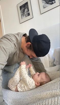 a man playing with a baby on top of a bed