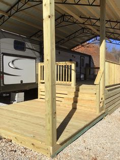 an rv is parked under a covered area with stairs and railings to the side