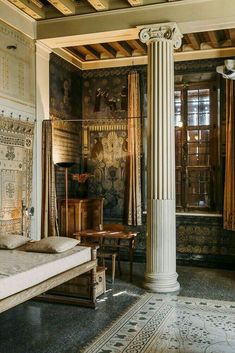 an old fashioned bedroom with columns and tapestry on the wall