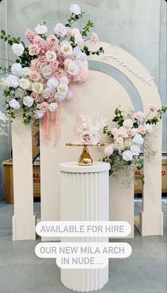 a white table topped with flowers next to a wall