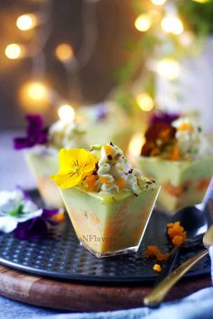 two desserts on a plate with flowers and lights in the backgroung