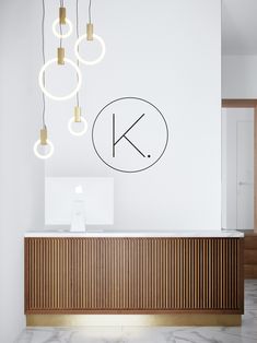 a reception table with lights hanging from it's ceiling and the letter k above it