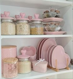 the shelves are filled with pink dishes and other kitchenware, such as heart - shaped plates