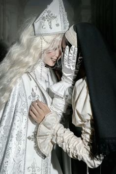 a woman dressed in white with long blonde hair