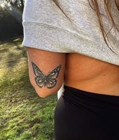 a woman with a butterfly tattoo on her left arm and lower half of her body