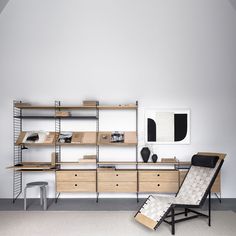 an empty chair sits in front of a desk with shelves and bookshelves on it