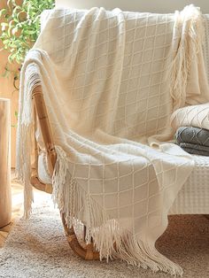 a white blanket sitting on top of a wooden chair