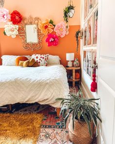 a bedroom with orange walls and flowers on the wall