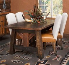 a dining room table with white chairs and an antelope centerpiece