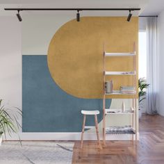 an orange and beige wall mural in a living room with a chair, bookshelf and potted plant