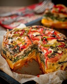 a vegetable quiche with one slice cut out and the rest removed from it's crust