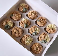 twelve cupcakes in a white box decorated with flowers