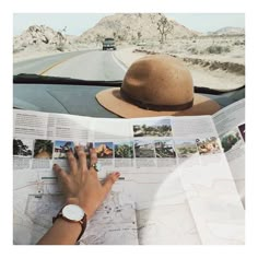 a person sitting in a car reading a map with a hat on top of their head