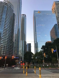 two tall buildings are in the background as traffic lights stand at an intersection on a city street