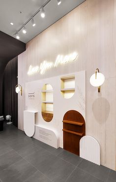 the interior of a store with white walls and wooden shelves on each side, illuminated by round lights