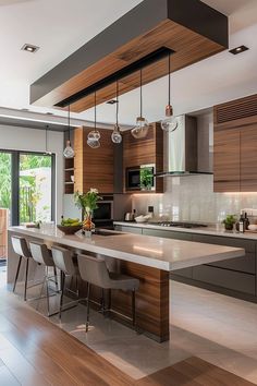 a modern kitchen with wooden cabinets and marble counter tops, along with bar stools