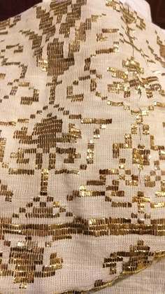 gold sequins on white fabric with wooden background