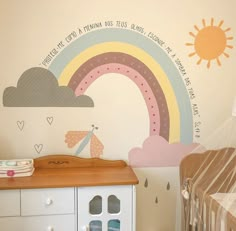 a child's room with a rainbow painted on the wall next to a crib