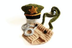 a crocheted hat, scarf and handcuffs on a white surface with a green cord