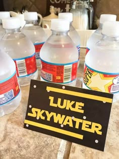 several bottles of water sitting on top of a counter next to a sign that says luke skywater