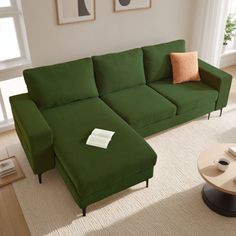 a green couch sitting on top of a living room floor next to a coffee table