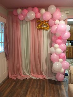 the balloon arch is decorated with pink, white and gold balloons