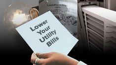 a person holding up a sign that says lower your utility bills in front of an air conditioner