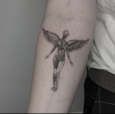 a woman's arm with a tattoo on it that has a skeleton and wings