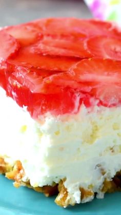 a piece of cake with strawberries on top sitting on a blue plate next to a fork