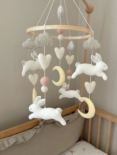 a baby crib with an animal mobile hanging from it's side