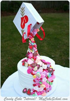 a white cake with pink and red sprinkles sitting on top of it