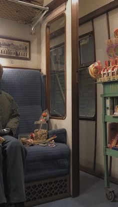 a man sitting on a train next to a shelf with candies and lollipops