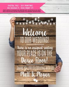 a man holding up a wooden sign with the words welcome to our wedding on it